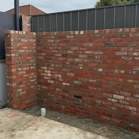 L shaped red brick corner wall with rustic multi tone bricks