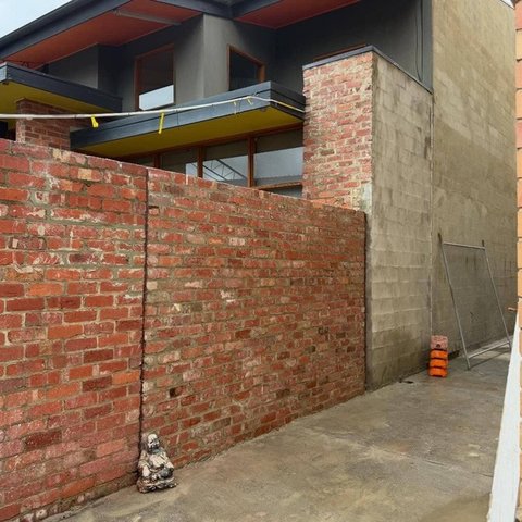 Recycled red brick wall alongside grey blockwork on a modern home