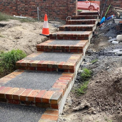 Outdoor brick edged stairs with exposed aggregate concrete treads