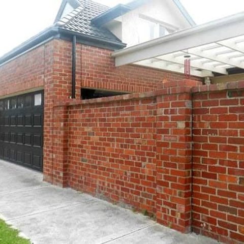 Red brick garage and matching boundary wall with pergola
