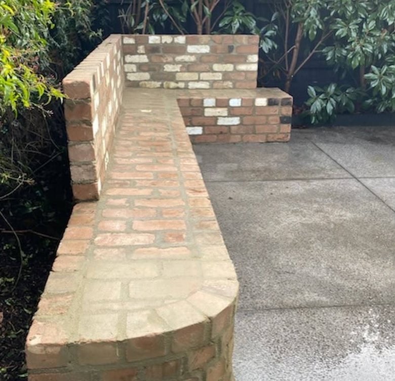 Custom L shaped recycled brick garden bench with curved end