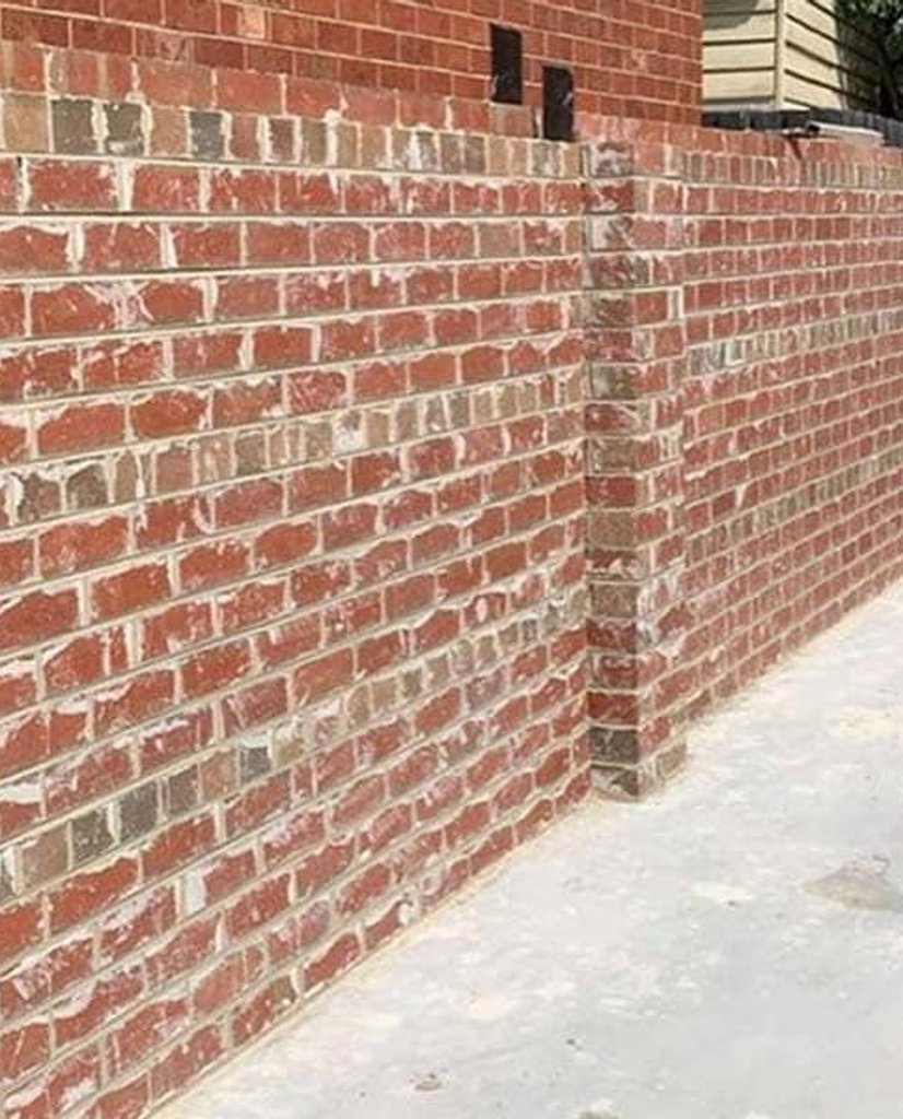 Red brick boundary wall with structural pillar on a residential site