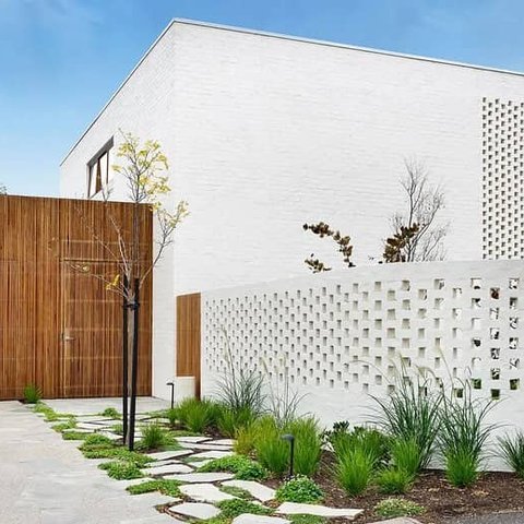 White painted brick facade with decorative hit and miss perforated brickwork