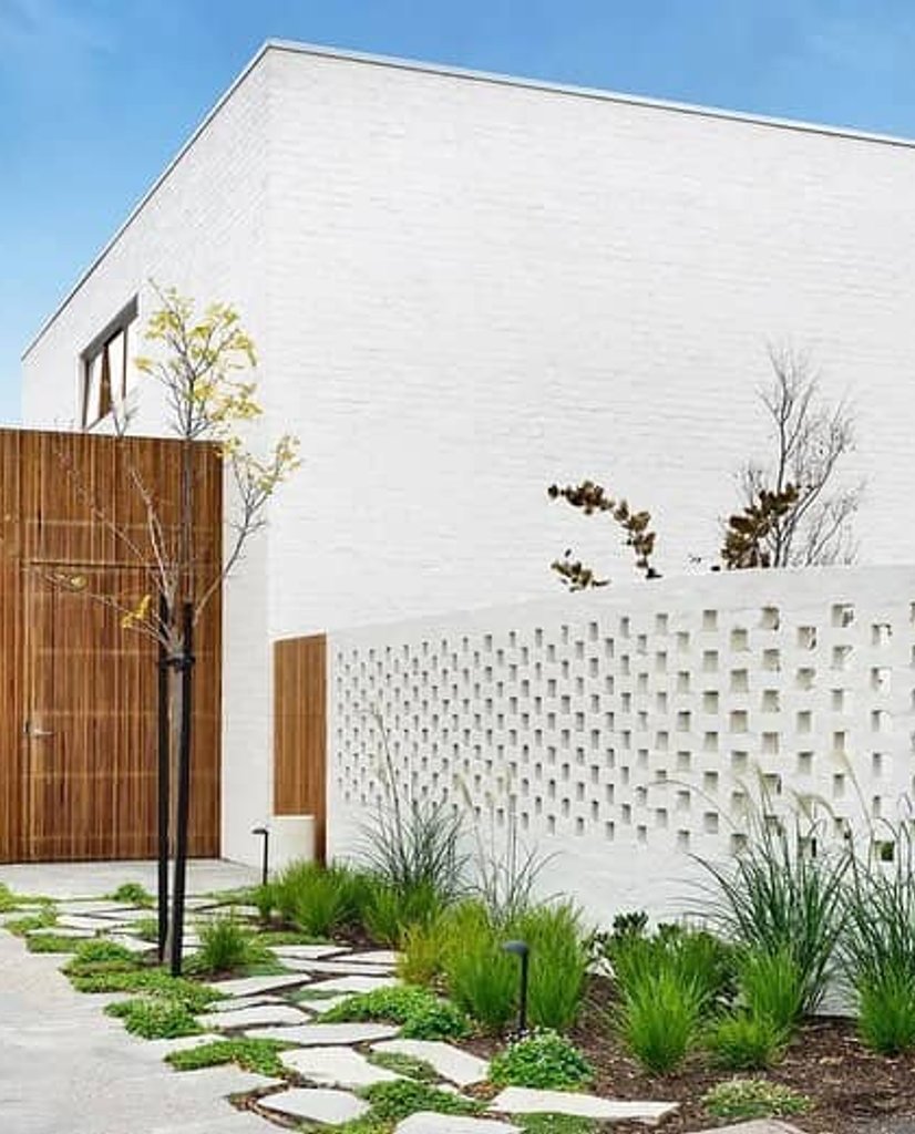White painted brick facade with decorative hit and miss perforated brickwork