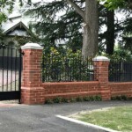 Open red brick fence with black cast iron bars by Alternative Bricklaying Open red brick fence with black cast iron bars