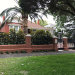 Open red brick fence with black cast iron bars by Alternative Bricklaying Open red brick fence with black cast iron bars